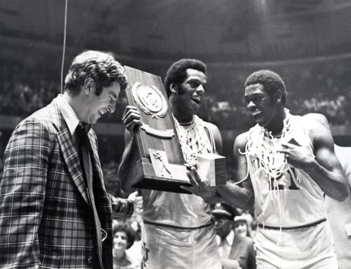 Indiana head coach Bobby Knight celebrates with forward Scott May (center) and guard Quinn Buckner (21) after winning the 1976 NCAA basketball championship. The Hoosiers beat the Wolverines 86-68.